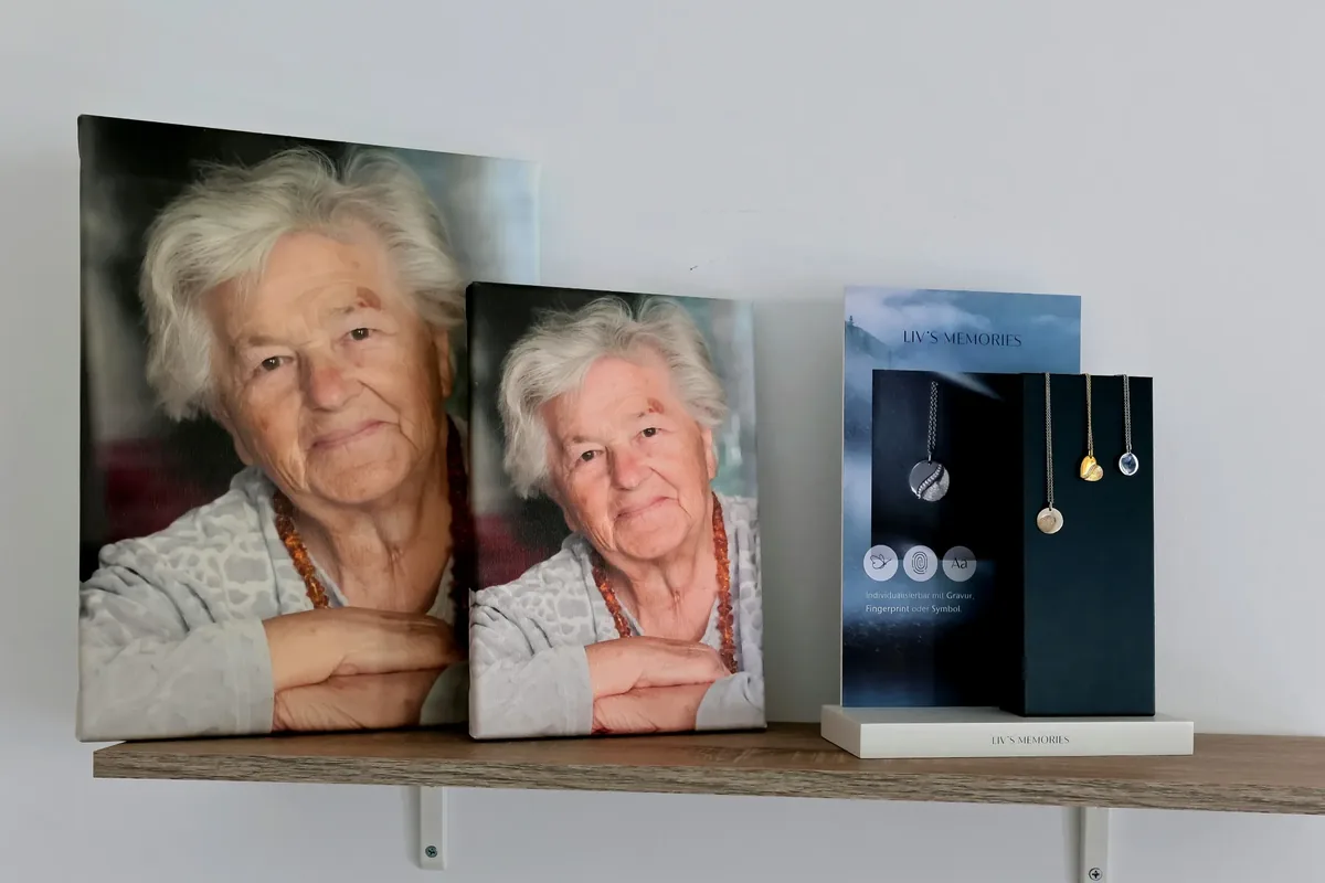 Gerahmte Erinnerungsfotos neben einer Präsentation von Gedenkschmuck